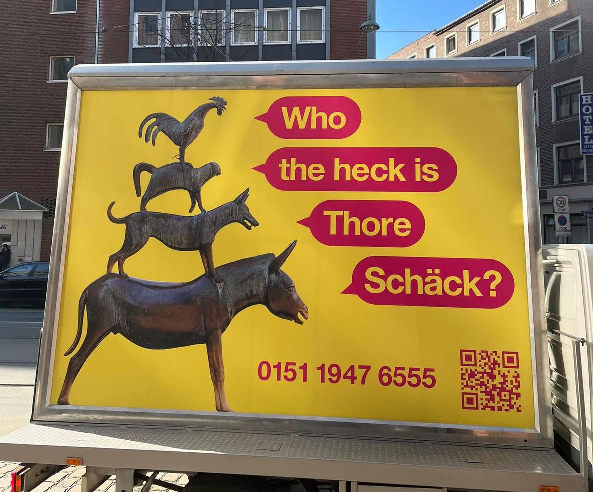 Fahrende Großfläche mit den Bremer Stadtmusikanten und Sprechblasen: Who the heck is Thore Schäck?